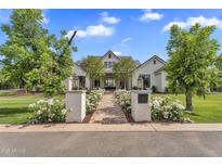 Stunning white brick home with lush landscaping and a charming brick pathway to the front door at 20649 E Vallejo Ct, Queen Creek, AZ 85142