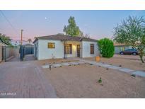 Charming painted brick home with desert landscaping and secure gated drive creates exceptional curb appeal at 2227 N 16Th Ave, Phoenix, AZ 85007