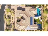 Stunning aerial view of a home with a tile roof, pool, basketball court, and solar panels at 37301 N 99Th St, Scottsdale, AZ 85262