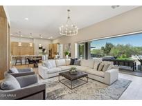 Bright living room featuring hardwood floors, modern lighting, and a large sectional sofa at 7032 E Balancing Rock Rd, Scottsdale, AZ 85266