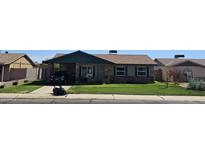 Charming single-story home with well-maintained lawn, covered porch, and paved driveway at 9157 W Gary Rd, Peoria, AZ 85345