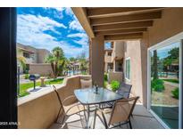 Enjoy outdoor living on this charming patio with a table set overlooking the community pool and lush landscaping at 9450 E Becker Ln # 1036, Scottsdale, AZ 85260