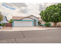 Charming single-story home boasts a three-car garage, desert landscaping and freshly painted trim at 10215 W Missouri Ave, Glendale, AZ 85307
