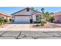 Charming single-story home with a two-car garage, well-manicured landscaping, and a welcoming entrance at 13233 W Mauna Loa Ln, Surprise, AZ 85379