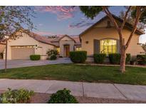 Charming single-story home featuring a well-maintained lawn and a two-car garage during a colorful sunset at 2045 E San Carlos Pl, Chandler, AZ 85249