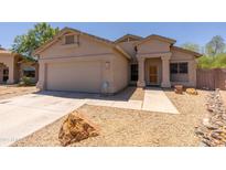 Charming single-story home featuring a stucco facade, desert landscaping, and attached two-car garage at 20986 N 66Th Ln, Glendale, AZ 85308