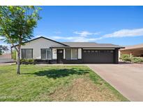 Charming single-story home with a well-maintained lawn, mature tree, and dark-colored garage at 540 W La Donna Dr, Tempe, AZ 85283