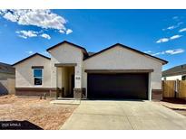 A single-story home featuring a stucco exterior, a dark garage door, and a well-maintained front yard at 5806 E Axle Ln, San Tan Valley, AZ 85140