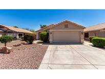 Charming single-story home with well-maintained landscaping and a two-car garage at 13439 W Desert Ln, Surprise, AZ 85374