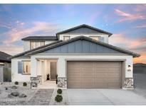 Charming two-story home showcasing a manicured front yard, a neutral color palette, and a spacious two-car garage at 15159 W Gray Fox Trl, Surprise, AZ 85387