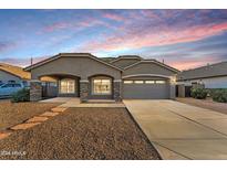 Charming single-story home with a well-manicured front yard and a covered entrance and a two car garage at 21759 E Estrella Rd, Queen Creek, AZ 85142