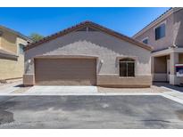 A tan stucco home featuring an attached garage with a brown garage door, and beige trim at 22225 N 29Th Dr, Phoenix, AZ 85027