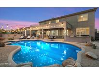 Backyard with a sparkling swimming pool, patio area, and lush desert landscaping at 22233 N 54Th Way, Phoenix, AZ 85054