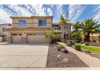 Charming two-story home showcasing a well-manicured front yard with lush landscaping and a three-car garage at 2302 S Canfield --, Mesa, AZ 85209