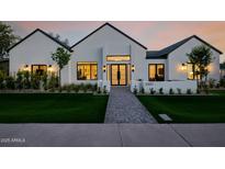 Striking modern home with a well-manicured lawn, walkway, and exterior lighting at 3301 E Elm St, Phoenix, AZ 85018