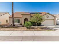 Charming single-story home with a desert-landscaped front yard and solar panels on the roof at 4207 W Soft Wind Dr, Glendale, AZ 85310