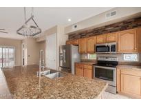 A kitchen featuring granite counters, stainless steel appliances, and custom wood cabinetry at 4617 E Culver St, Phoenix, AZ 85008