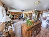 Open concept living room showcasing a fireplace, wood-look floors, and a ceiling fan at 4621 E Desert Forest Trl, Cave Creek, AZ 85331