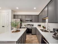 Modern kitchen featuring gray cabinetry, stainless steel appliances, and a stylish center island at 5518 S Dillon Cir, Mesa, AZ 85212