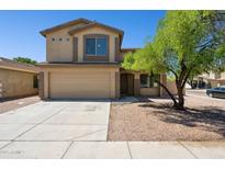 Charming two-story home featuring a two-car garage, neutral color palette, and a well-manicured front yard with mature tree at 5553 W Minton Ave, Laveen, AZ 85339