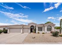Charming single-story home with a three-car garage, desert landscaping and a tile roof at 7492 E Buteo Dr, Scottsdale, AZ 85255
