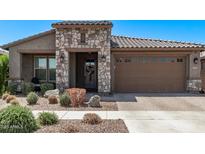 Charming single-story home featuring a stone facade, tile roof, and well-maintained landscaping at 10029 E Wavelength Ave, Mesa, AZ 85212