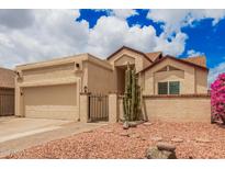 Charming desert home featuring low-maintenance landscaping, attached garage, and gated front entryway at 10244 N 65Th Ln, Glendale, AZ 85302