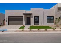 Contemporary home with a two-car garage, desert landscaping, and a clean, modern facade at 10332 E Utah Ave, Mesa, AZ 85212