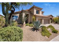 Beautiful home with desert landscaping, three-car garage, and a neutral-toned exterior at 14545 N 99Th St, Scottsdale, AZ 85260