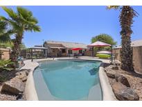 Inviting backyard oasis with a sparkling pool, lush landscaping, and resort-style amenities for relaxation and entertainment at 1518 E 12Th St, Casa Grande, AZ 85122