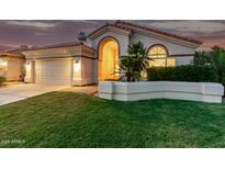 Charming home featuring a tile roof, manicured lawn, and an attached two-car garage at 1591 S Sycamore Pl, Chandler, AZ 85286