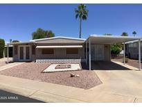 Charming single-story home with desert landscaping, awning-covered parking, and comfortable curb appeal at 2405 N Eastwood Way, Mesa, AZ 85215