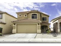 Charming two-story home featuring a tile roof, a two-car garage, and desert landscaping at 42006 W Hillman Dr, Maricopa, AZ 85138