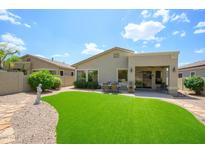 A well-maintained backyard featuring lush artificial turf and a covered patio with outdoor seating, perfect for relaxing at 5014 E Kirkland Rd, Phoenix, AZ 85054