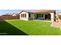 Spacious backyard with artificial turf, desert landscaping, and a covered patio for outdoor living at 6931 W Spur Dr, Peoria, AZ 85383