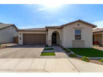 Charming single-story home featuring a well-manicured lawn, tile roof, and attached two-car garage at 6931 W Spur Dr, Peoria, AZ 85383