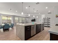 Open-concept kitchen with stainless steel appliances, an island, a nearby dining area and living room at 6931 W Spur Dr, Peoria, AZ 85383