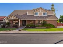 Charming two-story home with a well-manicured lawn and a welcoming front entrance. Includes a beautiful tile roof at 736 S Winthrop Cir, Mesa, AZ 85204