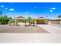 Charming single-story home featuring mature palm trees, desert landscaping, and a covered two-car carport at 8318 E Via De Los Libros --, Scottsdale, AZ 85258