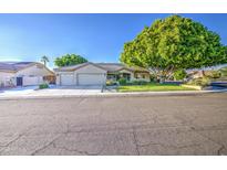 Charming single-Gathering home featuring a well-maintained lawn and a three car garage at 8748 W Maui Ln, Peoria, AZ 85381