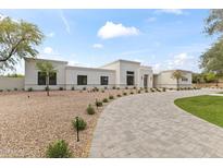 Beautiful single-story home featuring a paved driveway and desert landscaping at 9611 E Clinton St, Scottsdale, AZ 85260