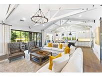 Bright living room with vaulted ceilings, hardwood floors, and open to dining area at 10179 E Camelot Ct, Scottsdale, AZ 85255