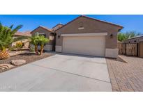 Inviting home with low-maintenance landscaping, paved driveway, and a two-car garage at 13523 W Remuda Dr, Peoria, AZ 85383