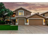 Charming two-story home featuring a well-manicured lawn and an attached three-car garage at 13566 N 93Rd Pl, Scottsdale, AZ 85260