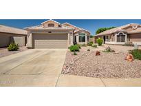 Charming single-story home with a well-maintained desert landscape and a two-car garage at 15558 N Ulrich Way, Surprise, AZ 85374