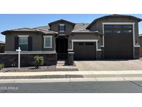 Charming single-Gathering home with a two-car garage and welcoming brick driveway and stone accents at 17427 W Hadley St, Goodyear, AZ 85338