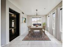 Cozy dining area with a chandelier, windows and hardwood floors at 4306 E Raven Rd, Phoenix, AZ 85044