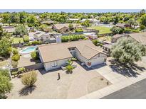 Aerial view of a home with a red tile roof, pool, green grass, desert landscaping, and a private back yard at 625 E Silver Creek Rd, Gilbert, AZ 85296