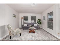 Inviting living room featuring neutral walls, grey sofa, and bright natural light at 11000 N 91St Ave # 101, Peoria, AZ 85345