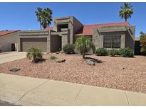 Charming single-Gathering home boasting a well-maintained exterior with a xeriscaped front yard and mature palm trees at 11106 E Clinton St, Scottsdale, AZ 85259